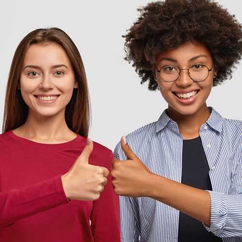 two happy friends with thumbs up
